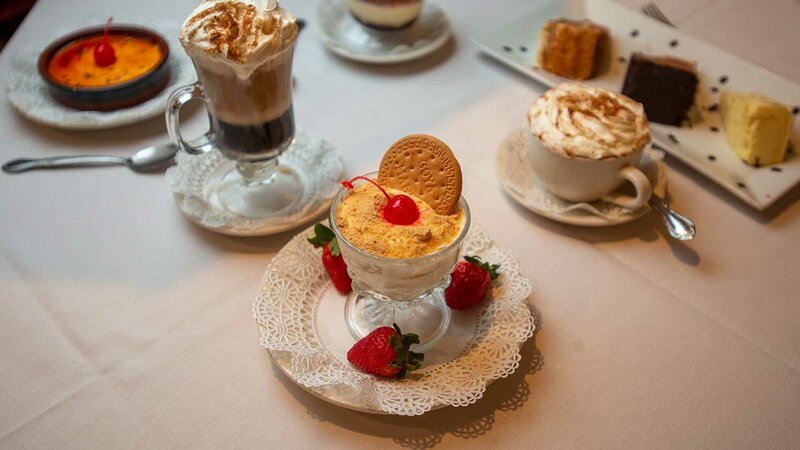 Custard dessert topped with a cherry and cookie